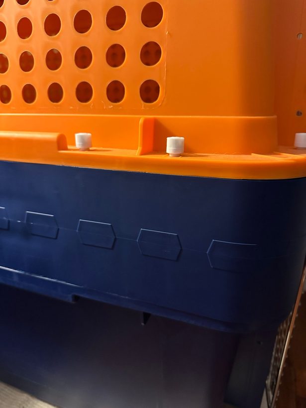 A plastic crate with a height extender fitted between the top and bottom halves