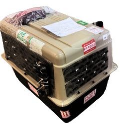 A crate with plastic mesh zip-tied over the side vents and door, labelled and ready